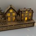Wooden Christmas light up decoration featuring a village scene with tree and houses. Laser cut wood is hand assembled with LED lights.
